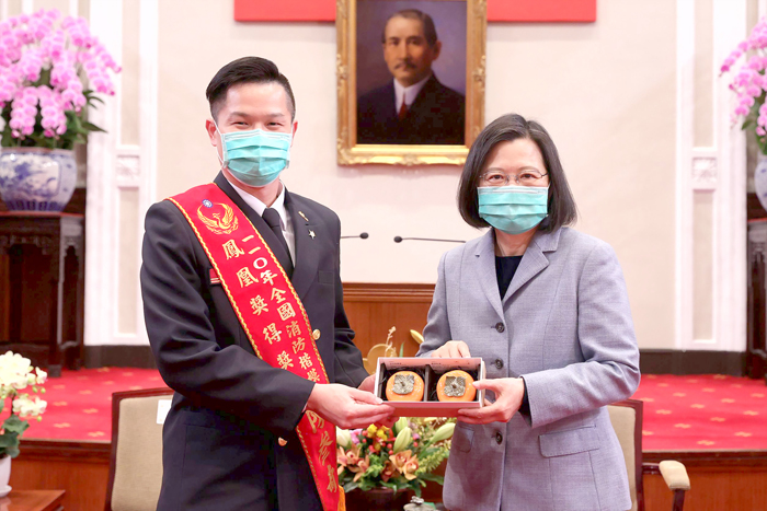 陳叁奇代表全國72位消防及義消楷模，接受總統致贈紀念品。
（金門縣消防局提供）