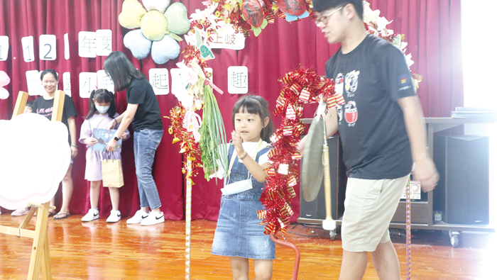 上岐國小辦理迎新活動，家長陪同小朋友穿過「青蔥」裝飾的聰明門。（上岐國小提供）