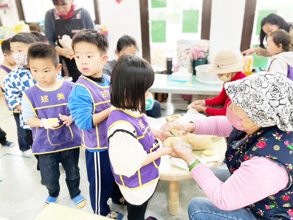 述美幼兒園辦理「紅龜粿」製作體驗，由愛心志工隊面授。（述美國小提供）