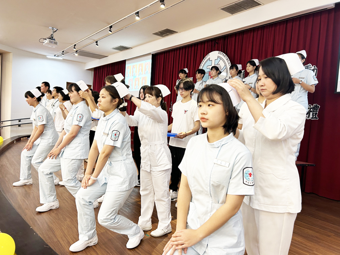 護理學系教師為即將步入專業實習的大一學生進行加冠授帽儀式。（許加泰攝）
