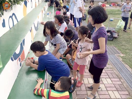 湖埔國小利用假日辦理「親子彩繪樂」活動，孩子們手持畫筆彩繪。
（李金鎗攝）