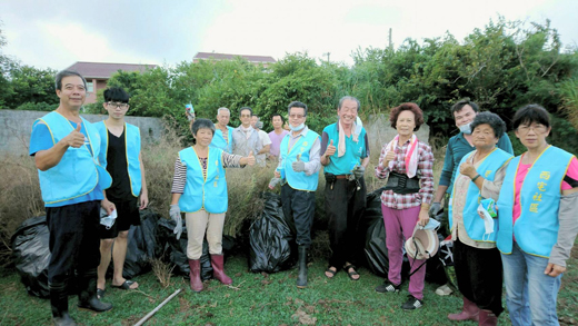 西宅社區發展協會理事長林世忠帶領居民利用假日來鋤銀膠菊毒草，減少毒草的飛散。（許加泰攝）
