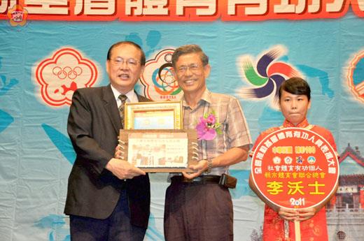 中華民國100年全國推動基層體育有功團體暨熱心人士表揚大會昨天移師金門縣隆重舉行,金門縣長李沃士榮獲推動社會體育有功個人獎,由副縣長吳友欽(中)上台代表領獎。(楊水詠攝)