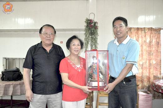   金寧鄉代會主席楊萬山贈送紀念品予即將退休的村幹事吳金喜，祝福夫婦倆一起享受退休生活。
（許加泰攝）