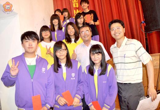   周佳汶（左三）、陳厚禎（左二）、陳志富（左一）以及在湖中校園歌唱比賽中得獎的學生與校長吳啟騰（右二）、主任謝志偉（右一）合影。（張建騰攝）