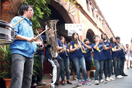   金大管樂社昨在模範街快閃演出，吸引不少民眾駐足觀賞。（董森堡攝）