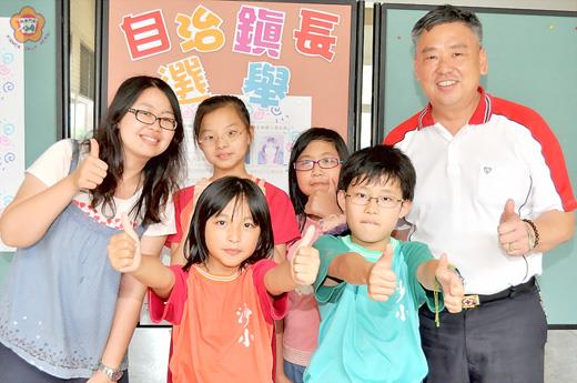   金沙國小一○一年自治鎮鎮長選舉揭曉，王芃、張芸銘（前排右至左）當選鎮長及副鎮長，師生一齊比讚肯定兩人的努力。（陳麗妤攝）
