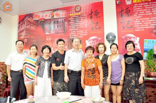 縣長李沃士昨至東門菜市場內的標記小吃視察建設局計劃案輔助成果,會後一行人並與店內成員拍照留念,在老店新生的標記小吃店留下見證。(董森堡攝)