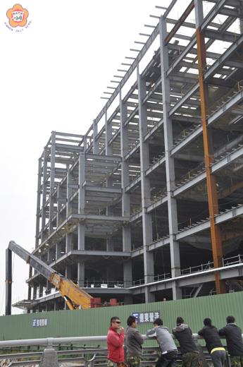   昇恆昌商務旅館新建工程發生租用吊車斷臂，驚動了四鄰，引起人們好奇圍觀。（張建騰攝）