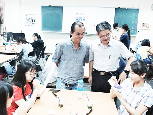 金門風獅爺創作達人王明宗教導學生彩繪風獅爺。(李金鎗攝)