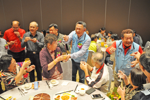 金門縣長楊鎮浯與社會處長董燊向模範老人和家屬親友敬酒,祝重陽節快樂。(楊水詠攝)