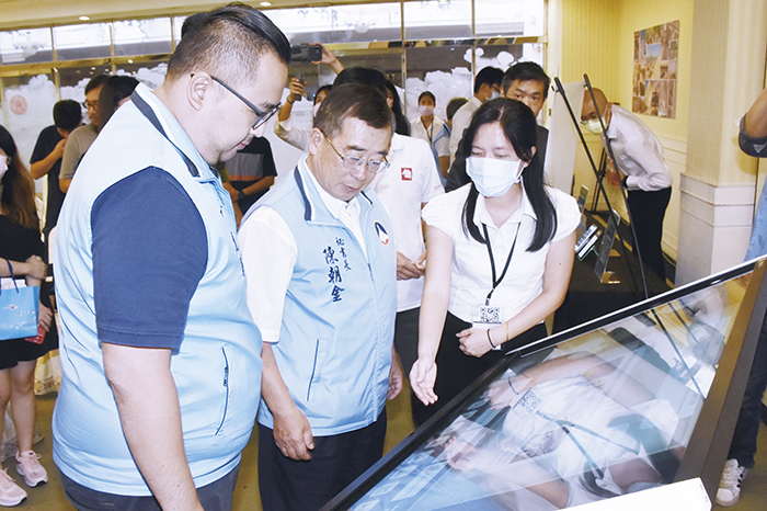 秘書長陳朝金與觀光處長丁健剛聽取廠商說明各項旅遊服務系統特色。（莊煥寧攝）