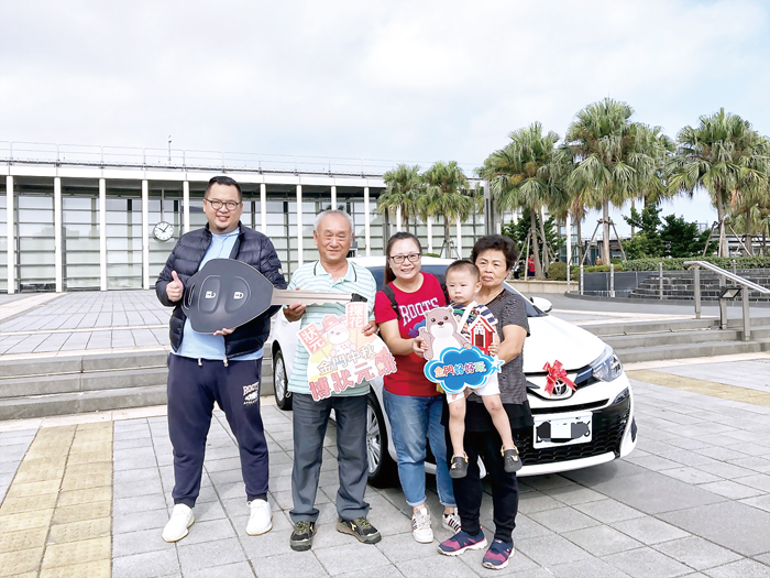 縣府觀光處長丁健剛（左1）昨日親赴桃園送汽車，吳姓得獎人（左2）全家開心領獎。（縣府觀光處提供）
