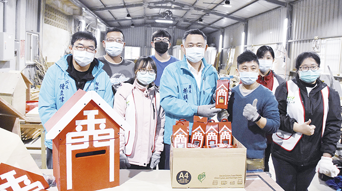 眾志成城展開復刻金門電話亭公益活動，縣長楊鎮浯前往林務所木工廠關心慰問，也在陳志偉、吳有祥等人的指導下小試身手，並準備精美小點心贈送給志工們，期許這股愛的能量能傳遞出去。（陳麗妤攝）