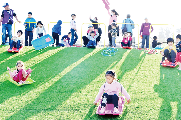 鄉長洪若珊陪同家長、小朋友一起體驗共融遊憩區的設施，小朋友樂透了。（許加泰攝）