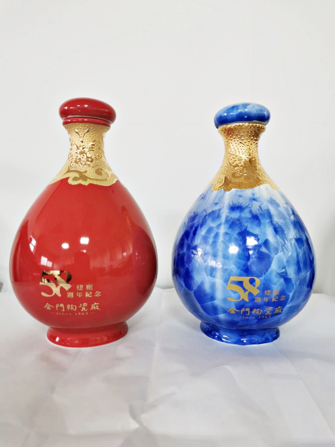陶瓷廠推出兩款建廠58週年紀念酒，一為材質彩金結晶釉的「巧奪天工」（右），一為外觀彩金中國紅的「土火純青」（左）。（陳冠霖攝）