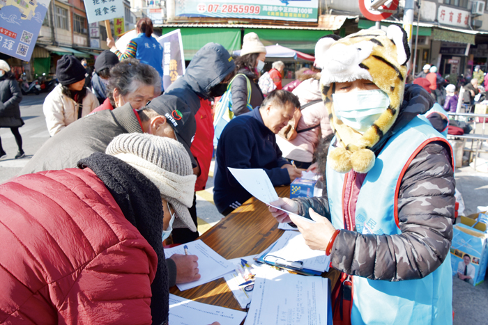 響應國民黨反萊豬護食安的連署活動，9日在代天府一帶消費的民眾具名寫下個人資料，希望全國同意連署數能達到公投案成立的門檻。（詹宗翰攝）