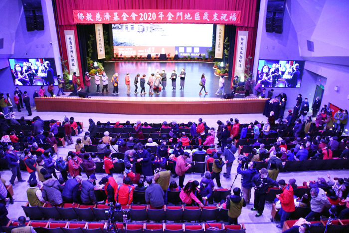 慈濟舉辦歲末祝福活動，民眾排隊上台領受由德寰、德林兩位師父分別發放的福慧紅包。（詹宗翰攝）