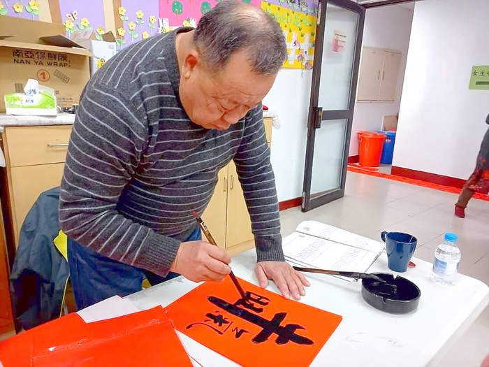 金寧鄉公所舉辦新春揮毫送春聯活動，邀請書法學會書法好手現場揮毫寫春聯。（李金鎗攝）