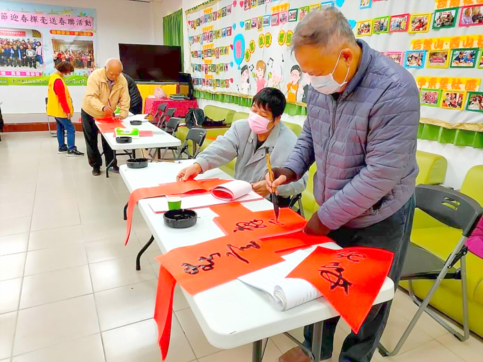 金寧鄉公所舉辦新春揮毫送春聯活動，邀請書法學會書法好手現場揮毫寫春聯。（李金鎗攝）