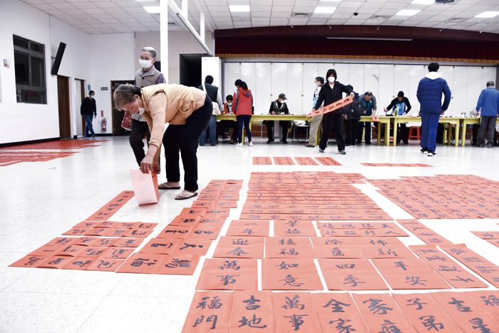 活動現場的地上滿滿是攤開等待墨跡收乾的春聯。（詹宗翰攝）