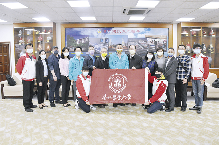 縣長楊鎮浯與臺北醫學大學副校長李飛鵬互換禮物，並與臺北醫學大學楓林幸服服務團隊合影。（楊水詠攝）