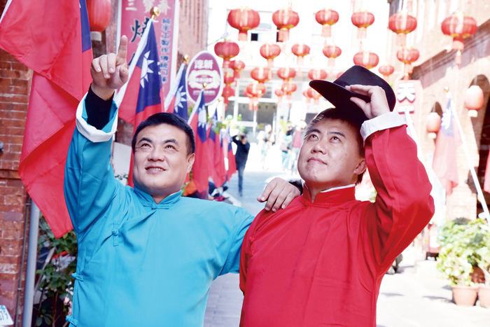 金城鎮模範街懸掛起紅色的燈籠。穿上民國初年的服裝在早年的洋樓建築間拍照，饒富趣味，金城鎮長李誠智邀請民眾也體驗「穿越」的妙趣。（詹宗翰攝）