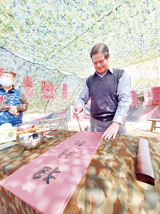 金門植物園邀請「將軍書法家」鄭有諒揮毫寫下春聯門葉，分送給遊客。（陳冠霖攝）