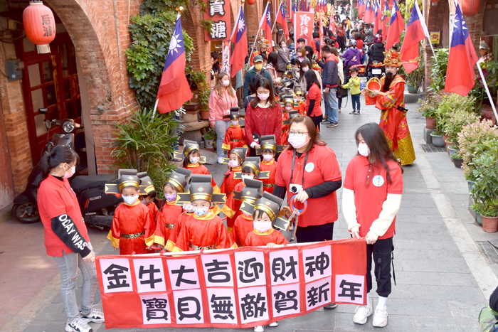 小朋友在師長及二位財神的帶領下，在金城市區遊街。（莊煥寧攝）