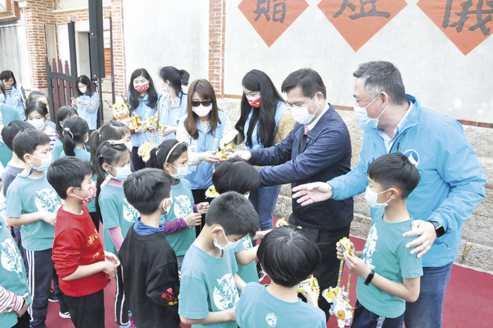 交通部長林佳龍、金門縣長楊鎮浯贈送交通部觀光局提供「活力牛」小提燈給在場的開瑄國小學童及與貴賓合影。(楊水詠攝)