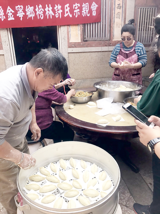 負責顧火爐炊粿的許振華，將菜粿送入「籠繩」。（許加泰攝）