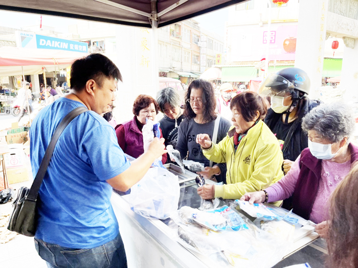 主打澎湖海鮮的攤位，在代天府前廣場擺攤，吸引上早市的民眾試吃、購買。（詹宗翰攝）