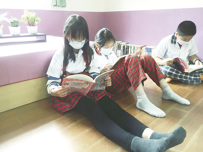 新北市板橋國小退休老師李聰任募書贈送金門縣小學,同學在閱讀角看書,享受閱讀的樂趣。(教育處提供)