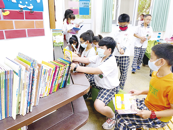 新北市板橋國小退休老師李聰任募書贈送金門縣小學,同學在閱讀角看書,享受閱讀的樂趣。(教育處提供)