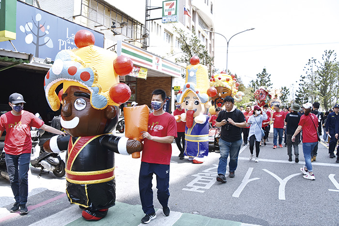 走在遊行隊伍前的神將、充氣神偶，醒目的模樣，吸引沿途民眾的目光。（詹宗翰攝）