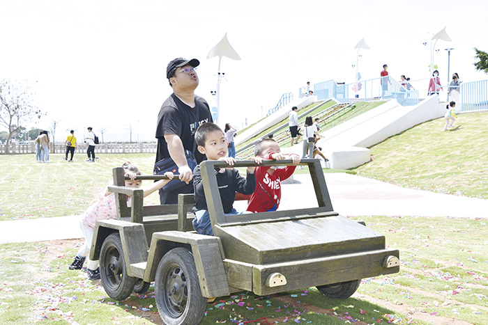 木製軍事車輛廣受大小朋友歡迎,推著在公園裡跑。(詹宗翰攝)