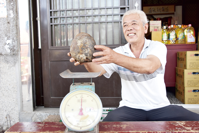葉福和帶著愛犬「多多」到海灘，發現疑似「龍涎香」的神秘石頭，重1.5公斤，鐵線烤熱後插入石頭會冒煙並有陣陣香氣。（莊煥寧攝）