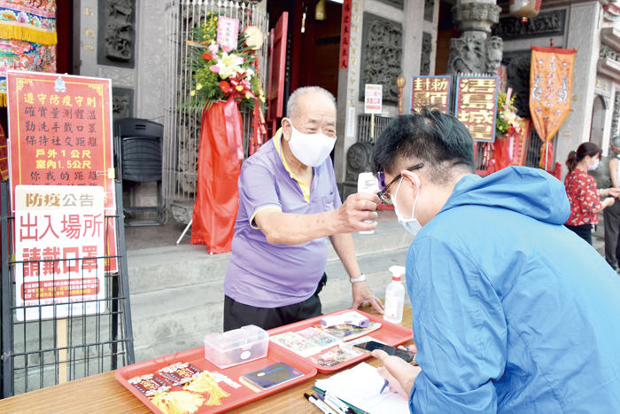 入廟前得先量體溫、噴酒精。(詹宗翰攝)