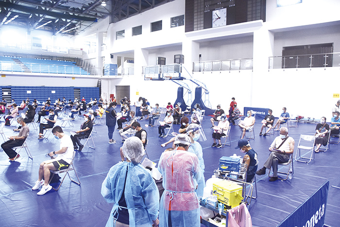 疫苗接種開放一至八類民眾施打，經預約成功的民眾前往接種站填寫資料後接種疫苗。（詹宗翰攝）