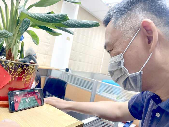金門縣長楊鎮浯透過手機觀看「麟洋配」東京奧運羽球男子雙打小組賽,為他們加油打氣。(縣府提供)