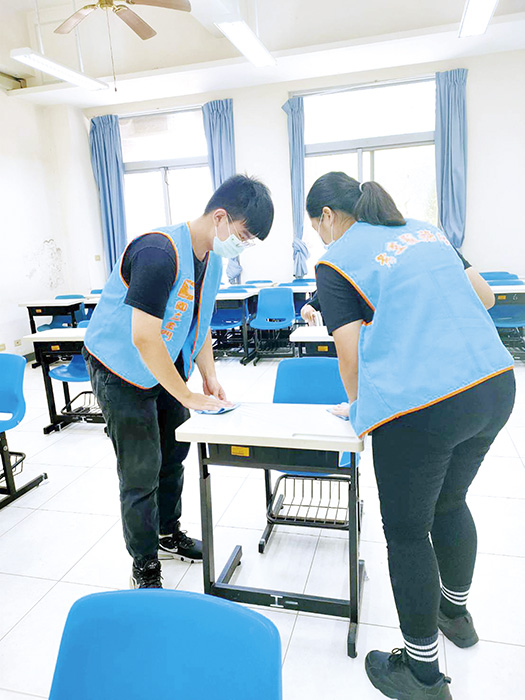 考區服務人員，會協助將桌面清潔乾淨和消毒。（金大提供）