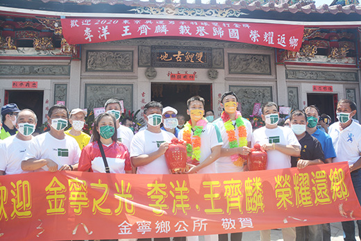 金寧鄉長楊忠俊於雙鯉古地致贈英雄酒給「麟洋配」,恭賀兩人羽藝高超,揚名世界。(高凡淳攝)