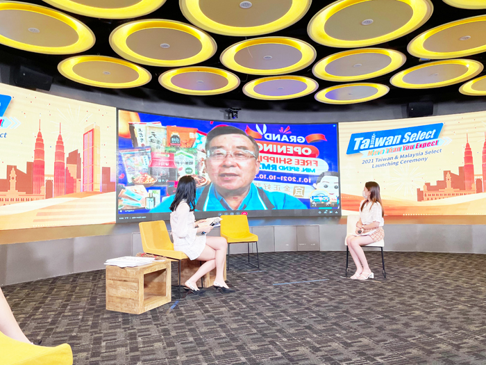 縣府秘書長陳朝金透過遠距連線方式，參與經濟部與馬來西亞官方共同舉辦的啟動儀式，並與網紅介紹本次參與的金門商品。（建設處提供）