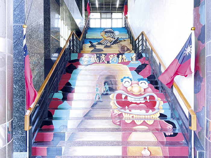 縣府觀光處邀請牧田創意彩繪工作室為金城民防坑道展示館入口處進行樓梯彩繪，並提前完工，這座彩繪樓梯藏有許多驚喜彩蛋，讓遊客以3D立體感的視覺感受多元面貌的金門在地元素。（縣府觀光處提供）