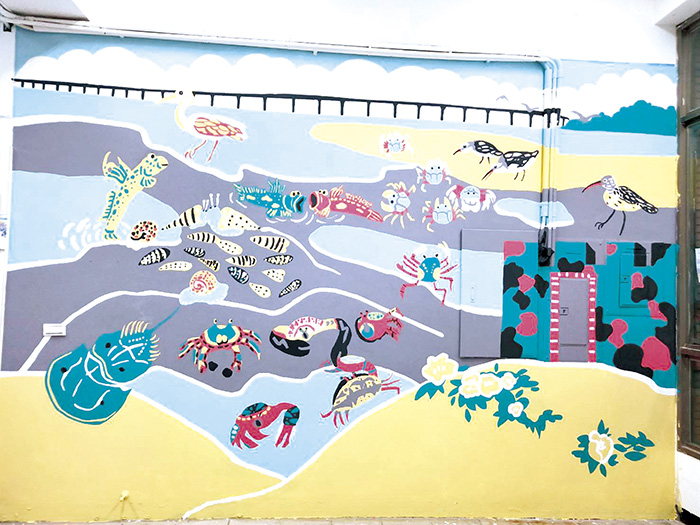 美術班學生將潮間帶生物彩繪在戶外教育與海洋教育中心的外牆上，形貌各異、色彩鮮艷的作品很是吸睛。（金城國中提供）