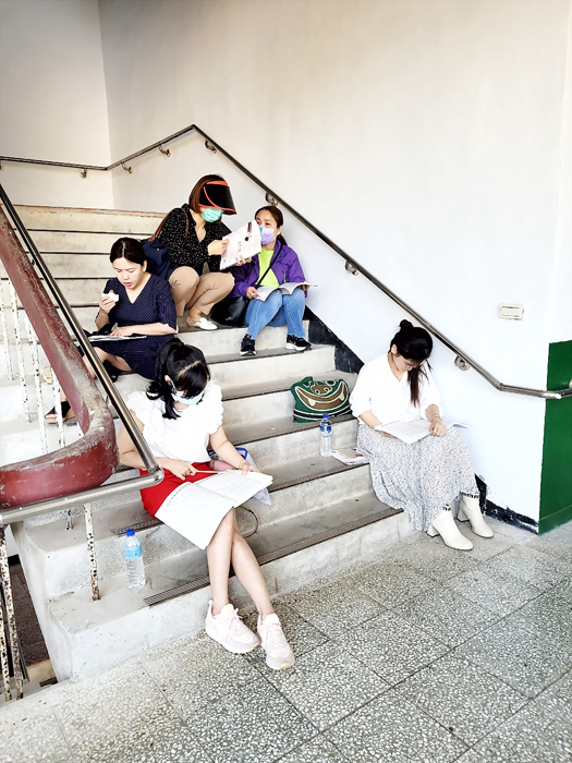 新住民姊妹應考110年度第2梯次全國技術士技能檢定學科測試,利用時間於學校的樓梯間K書。(新住民學習中心提供)
