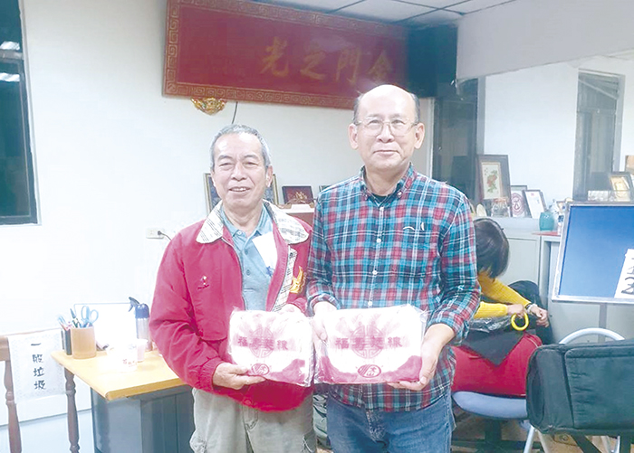 高市金同會理事長陳德順邀街頭藝人張尚平演出，贈以金門特產。（高市金同會提供）