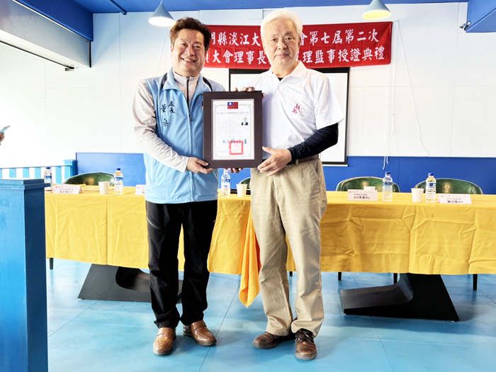 金門縣政府社會處長董燊頒發當選證書給淡江大學金門校友會第7屆理事長陳滄江。(李增汪攝)