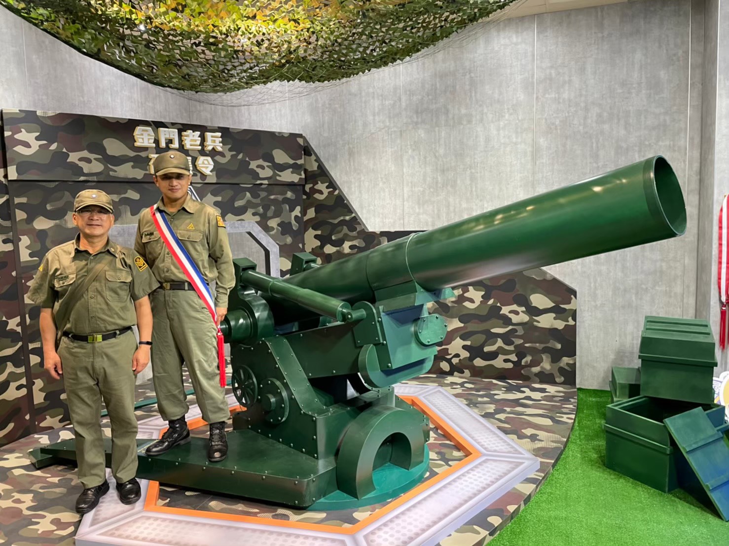 老兵志工邱棚鴻(右)與林德富穿著軍服執勤,化身「看板」人物,讓返金老兵秒憶戍衛前線的當兵情景。(縣府觀光處提供)
