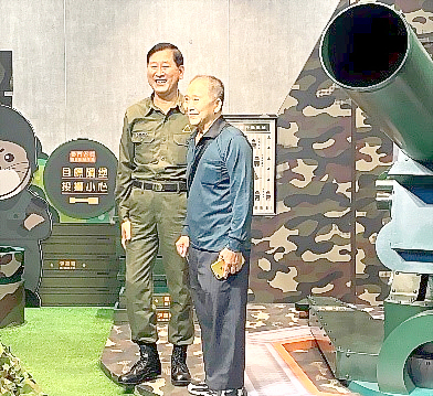 老兵志工邱棚鴻（右）與林德富穿著軍服執勤，化身「看板」人物，讓返金老兵秒憶戍衛前線的當兵情景。（縣府觀光處提供）